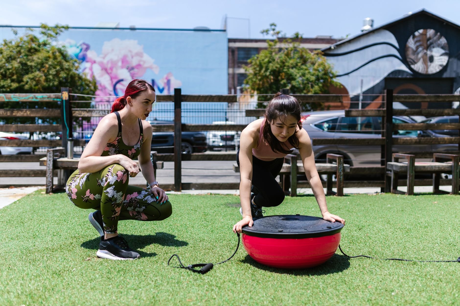 Two women exercising outdoors together, teamwork and fitness