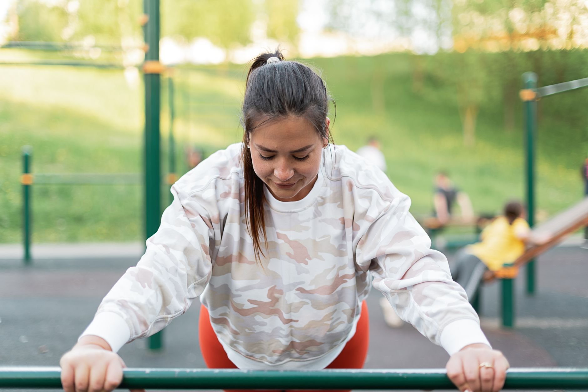 A woman performing exercises at an outdoor park, embracing a healthy lifestyle